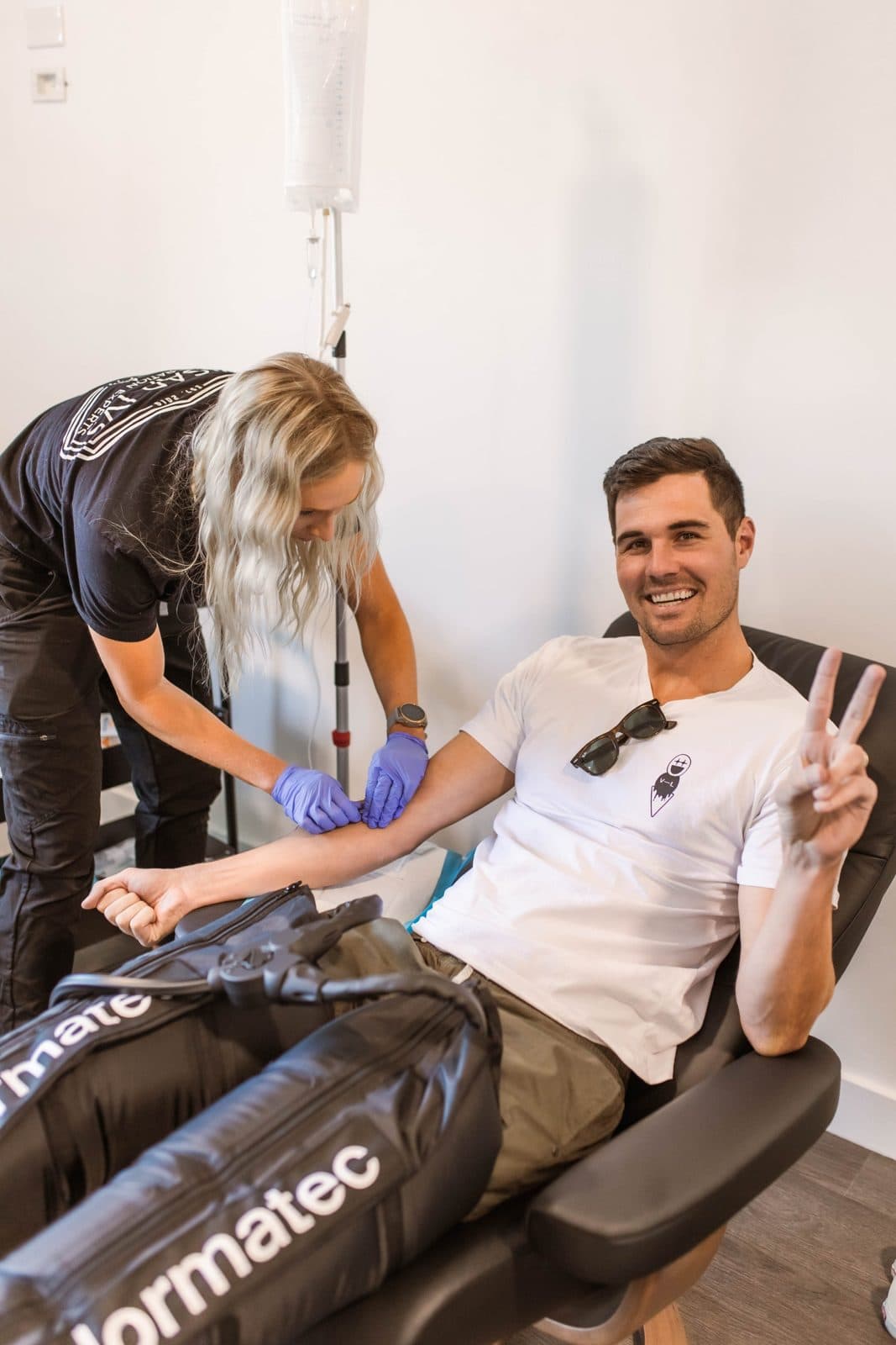 Recovery Room nurse setting up a smiling client's IV treatment