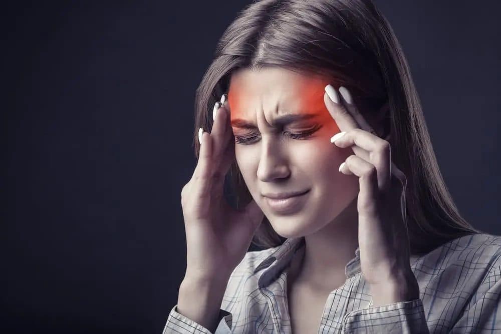 Woman pressing her temples during a migraine