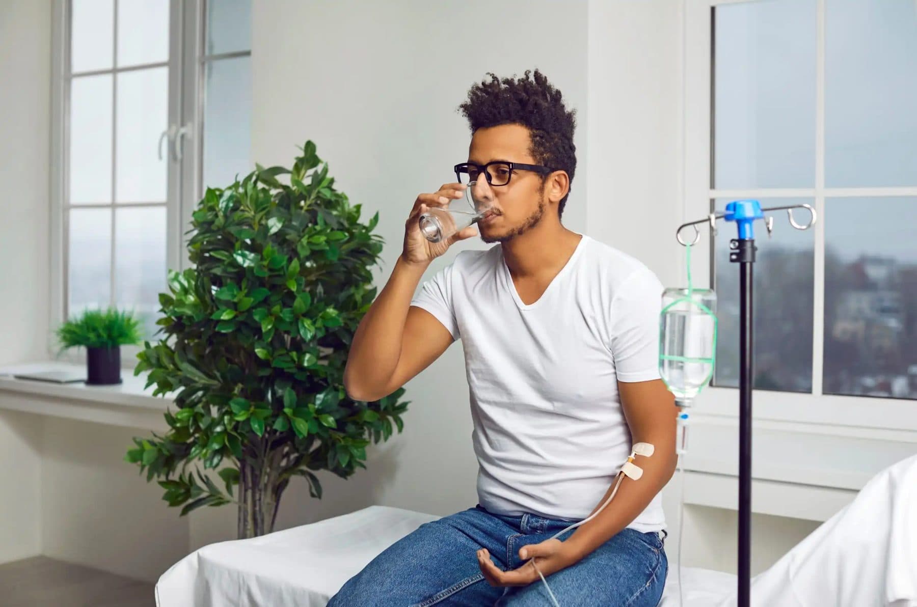 Client drinking water while receiving an IV drip