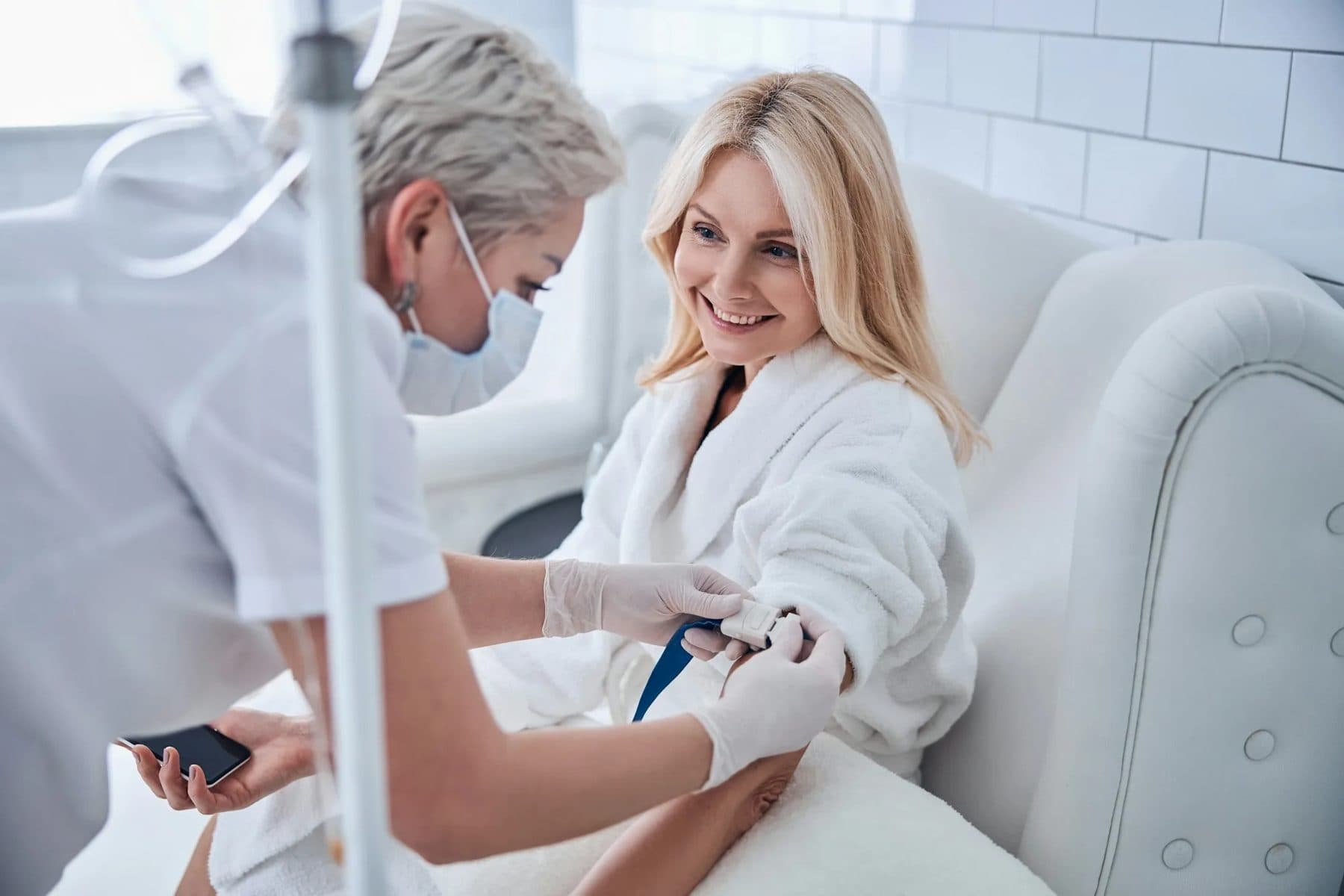Nurse administering IV therapy to a smiling, relaxed client