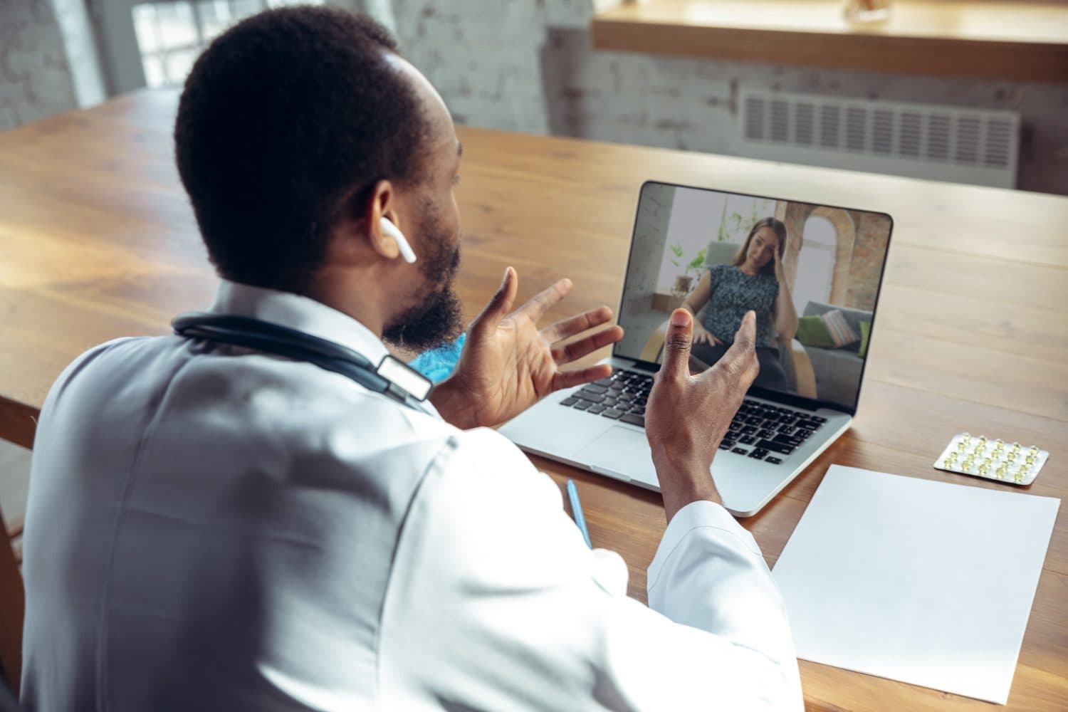 Physician conducting the required telehealth visit with a client